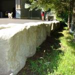 A solid Armour Stone wall supporting a driveway.