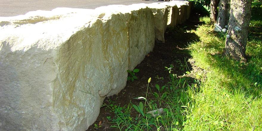 Armour Stone garden with river rock, mulch and shrubs in front yard.