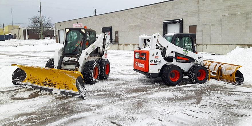 Snow plows in a commercial parking lot.