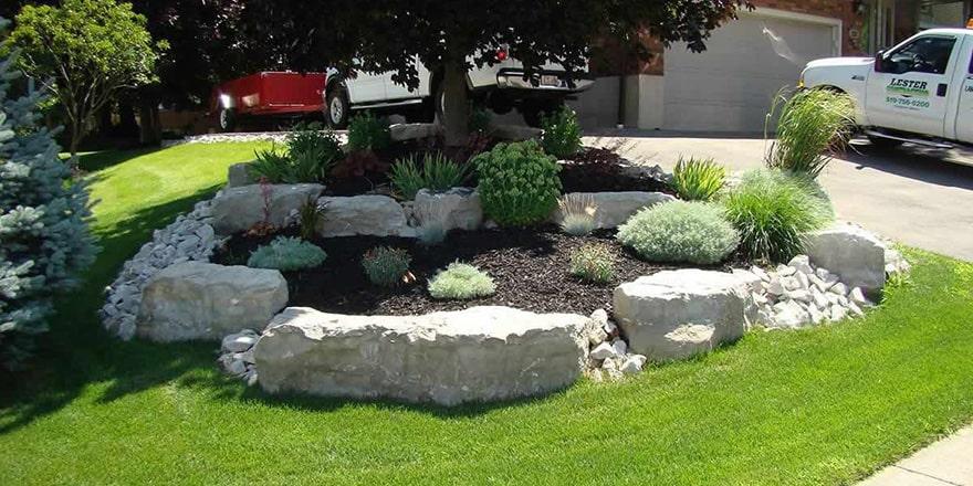 Armour stone garden with river rock and shrubs.